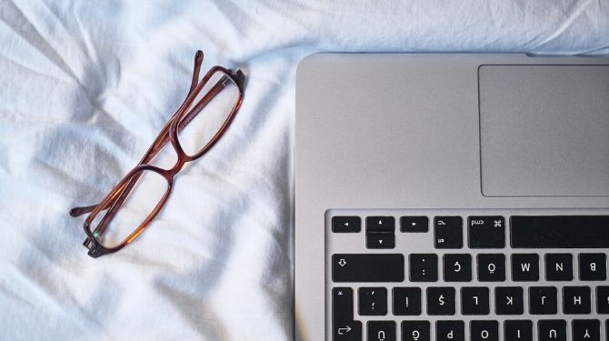 computer and glasses in bed