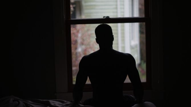 man meditating in bed